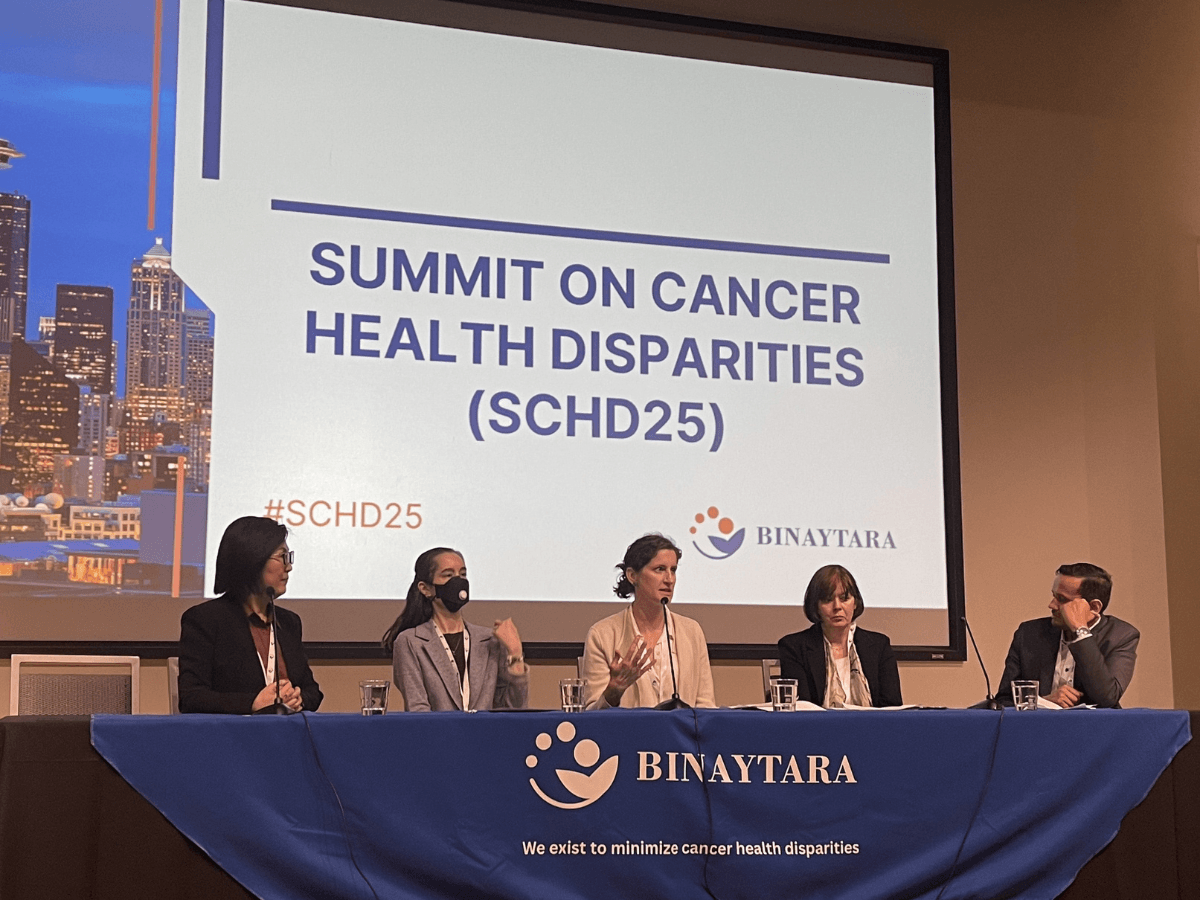 Panel discussion during SCHD25 Day 1 featuring expert speakers addressing implementation science, equity interventions, and cancer care access, with the Binaytara logo and Summit signage in view.