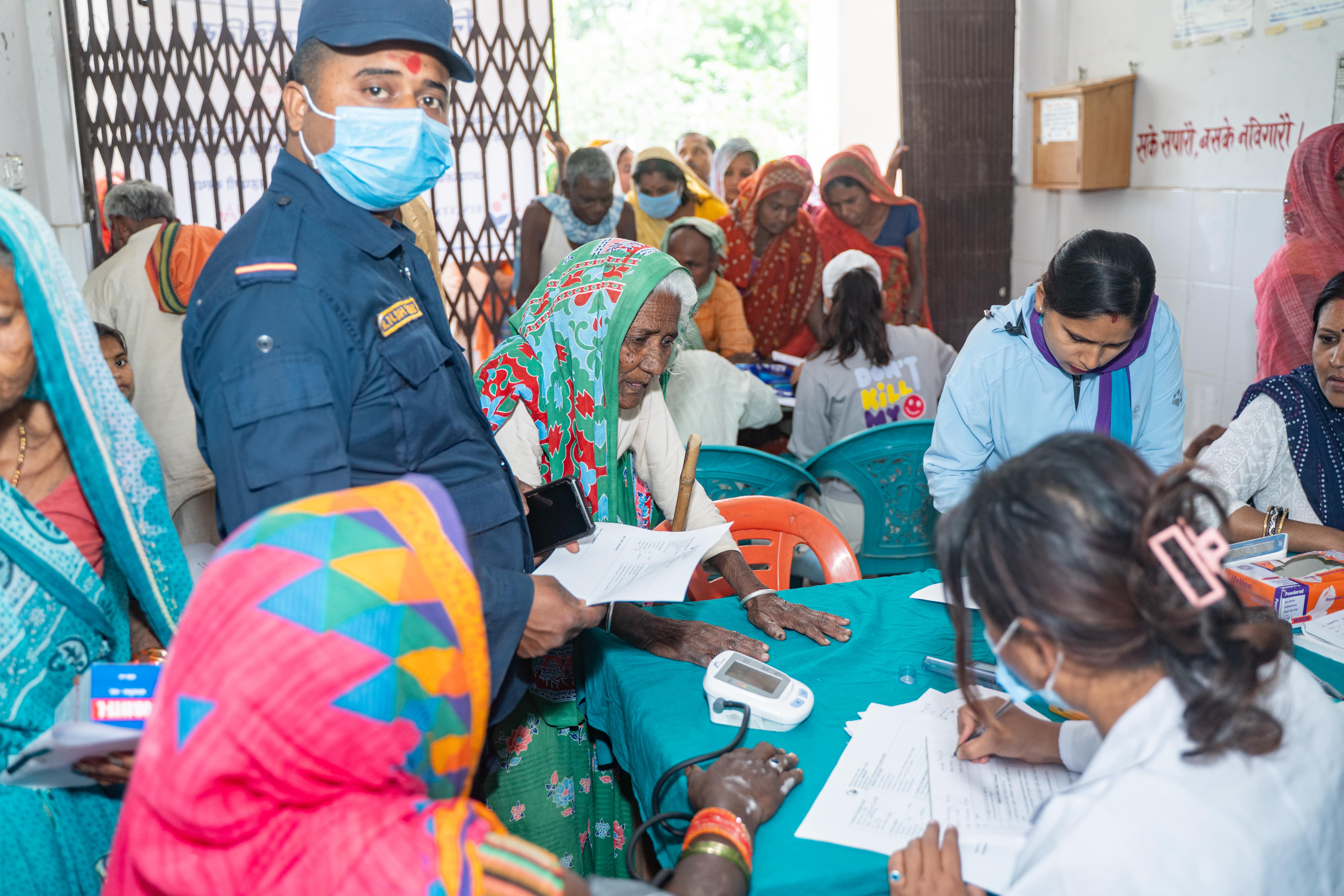 Women in a rural LMIC clinic receiving healthcare services, highlighting the importance of breast and cervical cancer screenings despite stigma.