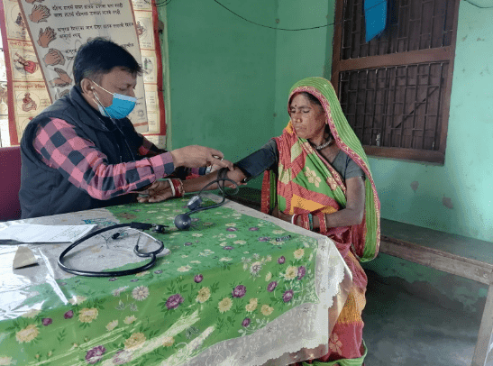 Healthcare provider checks blood pressure of a rural woman in Nepal during a Binaytara global oncology outreach program to address cancer disparities.