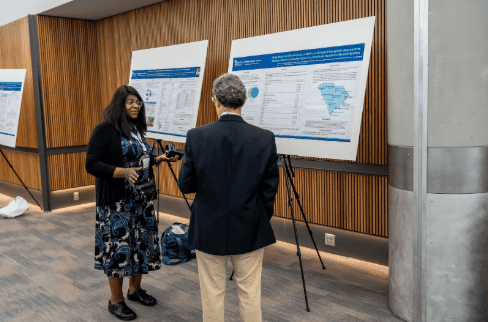 Dr. Marvella Ford presenting and discussing her SCHD25 award-winning cancer equity poster.