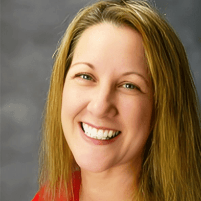 Judy Delismon, oncology nurse and Binaytara volunteer, smiling in a professional headshot