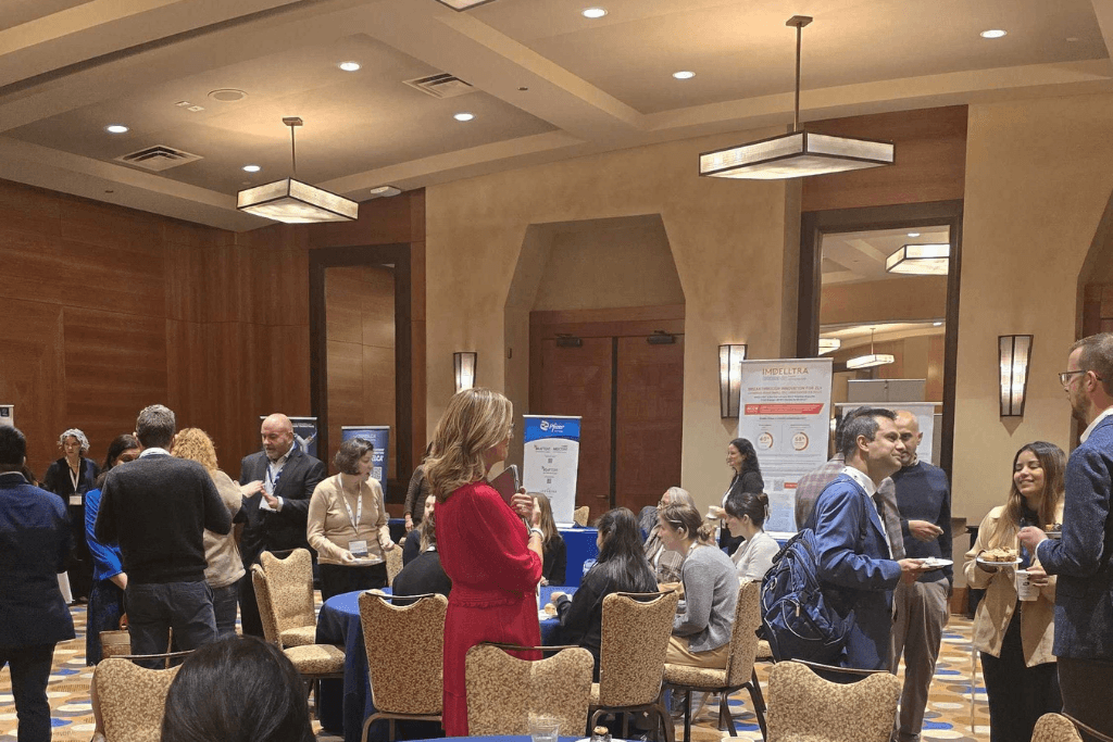 Conference participants networking and visiting exhibitor booths during a break at the Seattle Lung Cancer Conference.
