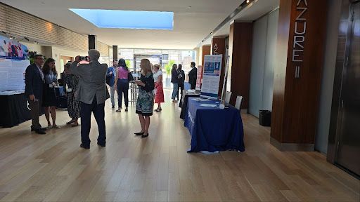 Exhibitors and clinicians networking and discussing cancer therapies in the Houston conference hall.