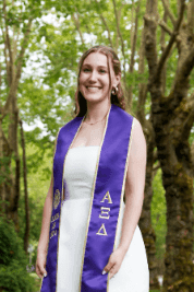 Emma Robinson at her University of Washington graduation, wearing a purple sash